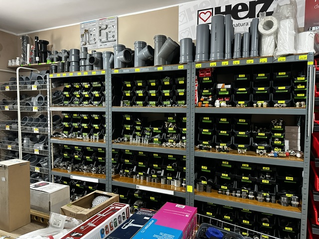 Regały z rurami, kształtkami i elementami instalacji hydraulicznych